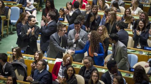 Model UN participants shaking hands.